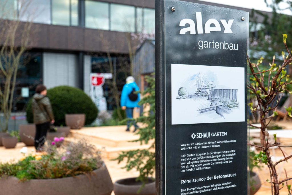 Gartenbau-Schild mit Besuchern im Hintergrund